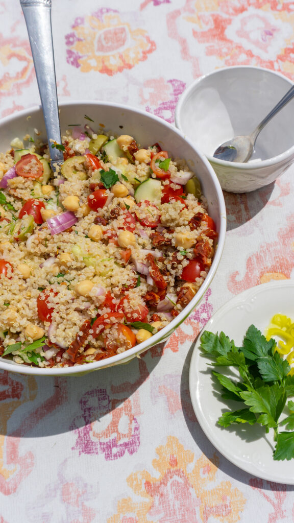 greek quinoa salad outside ready to serve on a picnic table