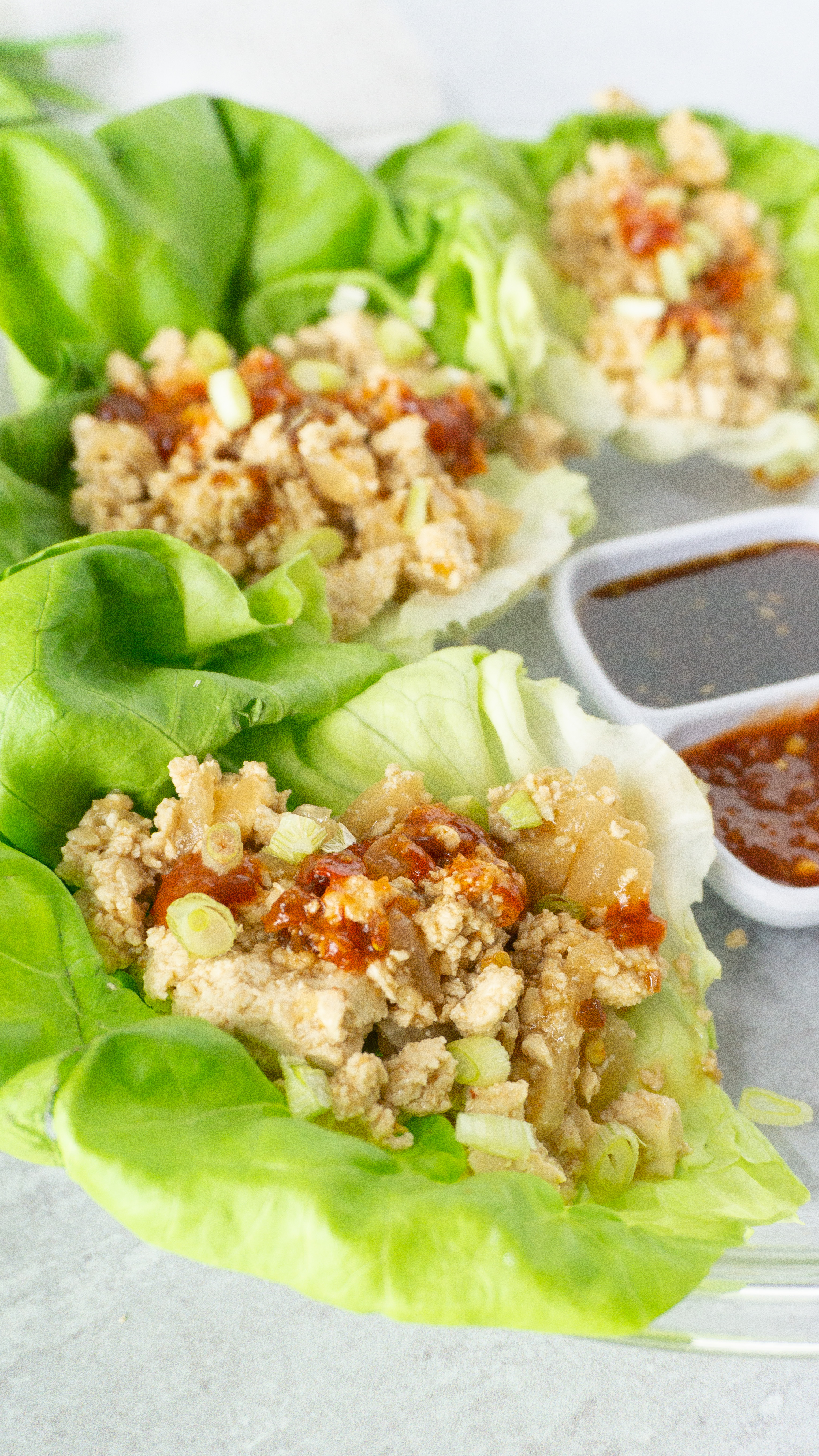 tofu lettuce wraps on a place with two different sauces in the middle