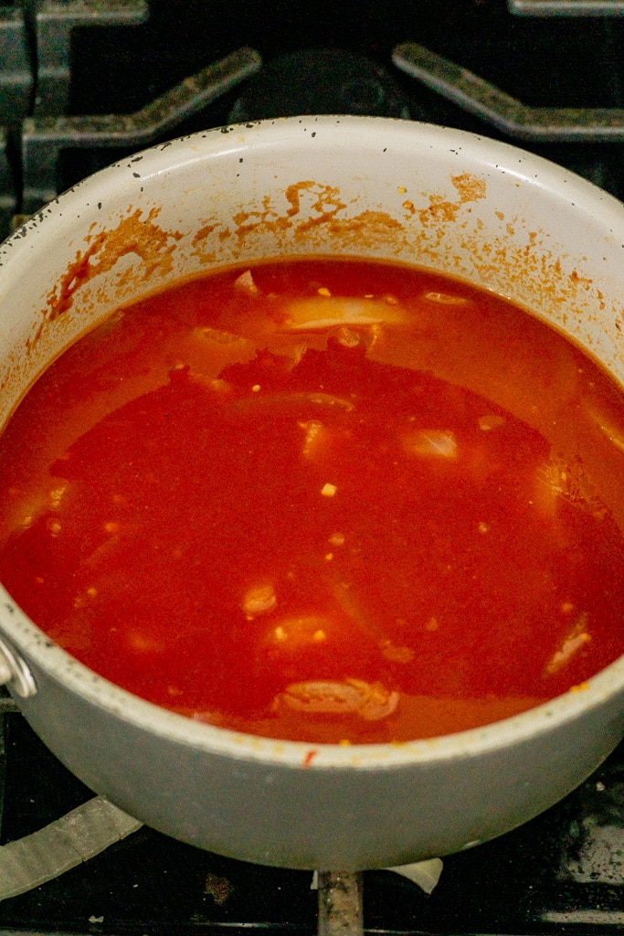 add tomato paste, broth, and onions to pan over medium heat
